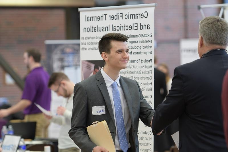 Student shaking an employer's hand at a career fair